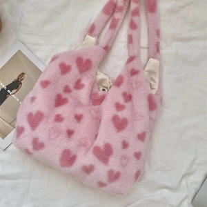 Detail of pink faux fur tote bag with heart patterns and magnetic snap closure