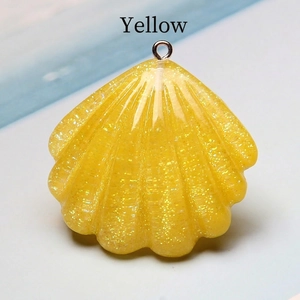 Macro detail of yellow resin scallop shell pendant with glitter and silver metal loop