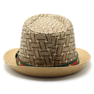 Detail of summer straw hat featuring red-green ribbon with small floral embroidery