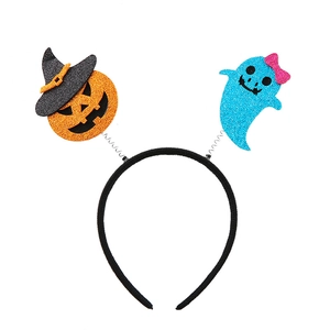 Detail of Halloween headband with glittery pumpkin and ghost on springs over a white background
