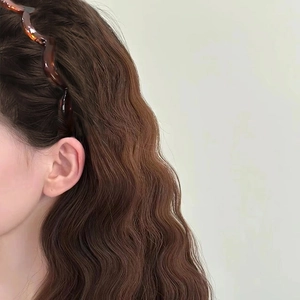 Serre-tête ondulé en écaille ambre pour femme avec vue latérale sur cheveux bouclés