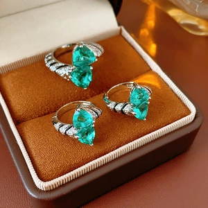 Macro view of three vintage silver rings with pear-cut emerald stones in a velvet box