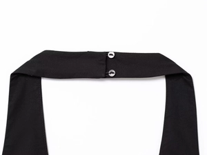 Détail du tissu sergé noir avec fermeture à double bouton argenté sur le col licou