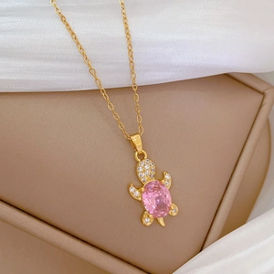 Detailed view of pink turtle pendant featuring crystal pavé on golden O-chain necklace