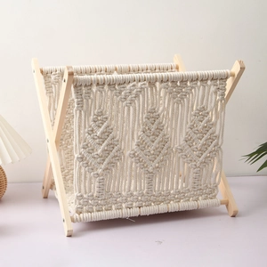 Detail view of the bohemian hand-woven cotton rope magazine rack with X-frame wooden stand