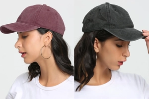 Close-up of washed cotton baseball caps in burgundy and charcoal black with curved brims