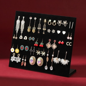 L-shaped black velvet earring display stand with multiple pairs of jewelry studs