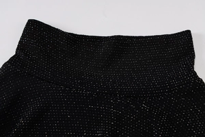 Détail du tissu noir scintillant montrant le col montant et les fils d'argent brillants
