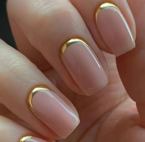 Detailed macro view of nude pink square nails with luxury gold French metallic edges