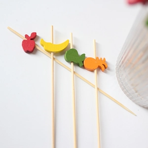 Bamboo fruit picks with colorful wooden strawberry and pineapple toppers for cocktails