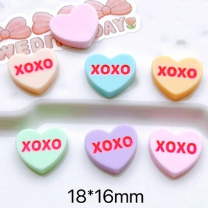 Macro shot of 18x16mm heart-shaped macaron resin charms with red XOXO lettering