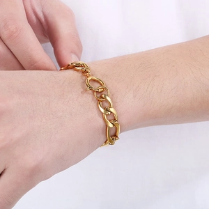 Close-up of chunky gold stainless steel curb chain bracelet with circular spring clasp