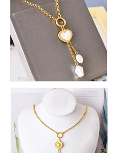 Détail du collier cœur doré avec incrustation en nacre et glands de perles baroques