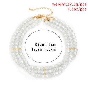 Close-up of bohemian layered pearl necklace with gold beads and lobster clasp detail