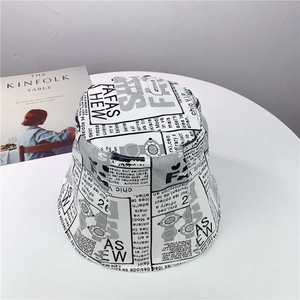 Detailed top view of canvas bucket hat featuring stylish black and white newspaper print
