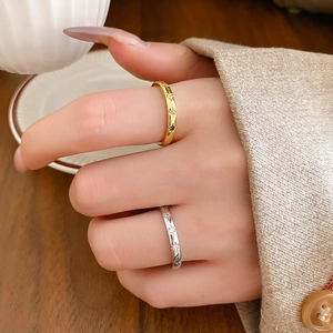 Close-up of gold and silver star-engraved rings with colorful zircon on a model