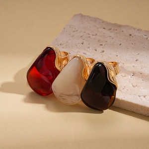 Ensemble de trois bagues dorées ornées de grandes pierres en résine colorée