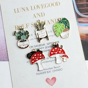 Enamel mushroom and potted plant pendants on vintage card for DIY jewelry making