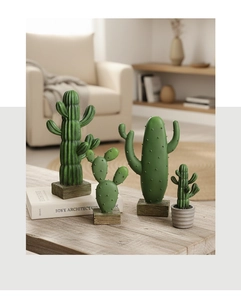 Close-up of four green resin cactus figurines with lifelike texture on a wooden desk