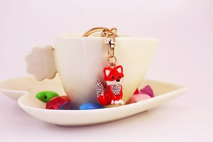 Close-up of red crystal fox keychain with gold metal plating and sparkling rhinestones