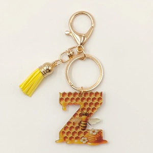 Detail of letter Z keychain with honeycomb pattern, yellow tassel and golden lobster clasp