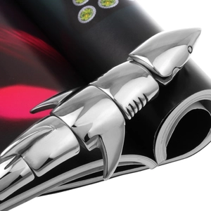 Detailed macro shot of silver mechanical shark bracelet on a black magazine background