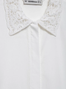 Détail du col en crochet blanc avec étiquette de taille M et texture en dentelle de qualité