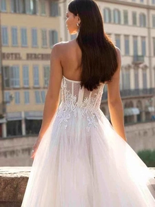 Détail d'une robe de mariée bustier blanche avec dentelle florale et dos en résille