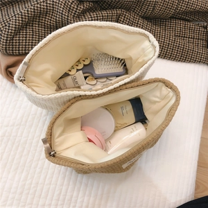 Close-up of vintage woven checkered cosmetic bag showing interior storage and capacity