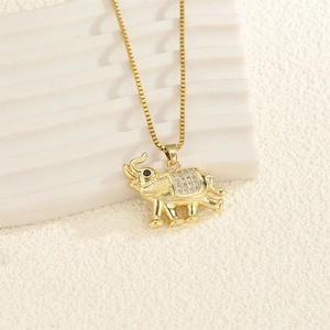 Close-up of golden elephant pendant with white cubic zirconia and black gemstone eye