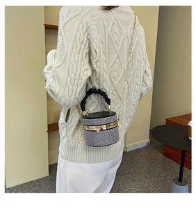 Detailed back view of a woman wearing the sparkling rhinestone cylinder bag with gold chain