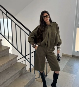 Detail of military green suede bermuda shorts and matching jacket with matte texture