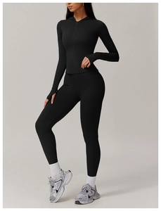 Detail of black hooded zip-up yoga set with high-waisted leggings and thumbhole cuffs