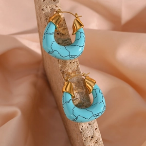 Detail of sky blue marble-patterned U-shape earrings on a natural stone surface