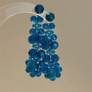 Detail of blue faceted crystal beads arranged in a cascading cluster drop earring
