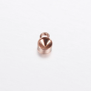 Detailed view of a round rose gold pendant base with bail for DIY jewelry making