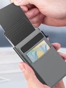 Detail view of the aluminum card holder showing the side ejection and cash storage slot