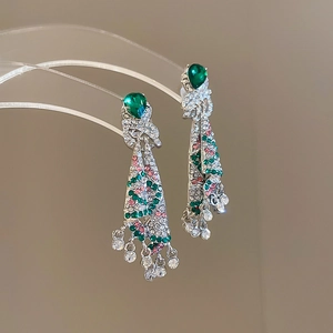Detail of silver drop tassel earrings with sparkling green and pink rhinestones