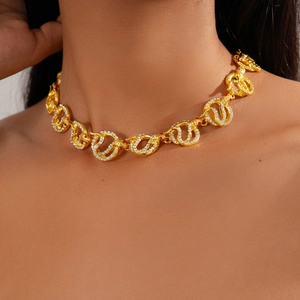 Macro shot of gold snake-link necklace with clear rhinestones and red jewel eyes