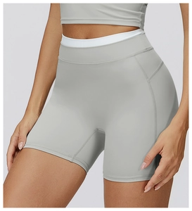 Détail du short de yoga taille haute avec bordure blanche contrastée et coutures renforcées