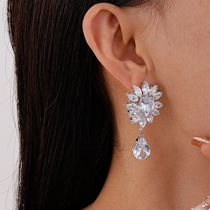 Gros plan de boucles d'oreilles pendantes en zircons avec fleurs et goutte d'eau