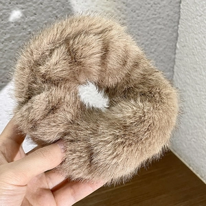 Close-up of soft brown plush scrunchie showing fluffy faux fur texture for women