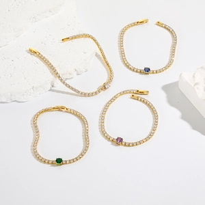 Detailed macro of gold plated tennis bracelets with emerald, sapphire and amethyst stones