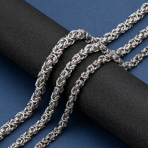 Macro shot of silver Byzantine chain necklace with intricate woven stainless steel links