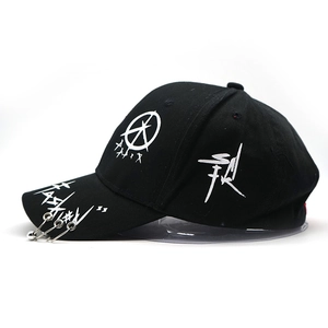 Detail of hip hop baseball cap with graffiti prints and three silver metal rings on the brim