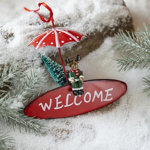 Christmas reindeer welcome sign with red umbrella pendant hanging on snowy pine branch