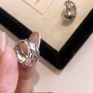 Detail shot of silver U-shaped hoop earrings with faceted diamond-cut geometric design