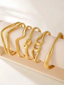 Macro shot of 18k gold plated stainless steel geometric bangles set on a jewelry display