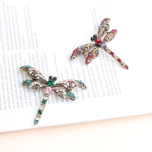 Close-up of vintage dragonfly brooches with multi-color rhinestones and hollow wing detail