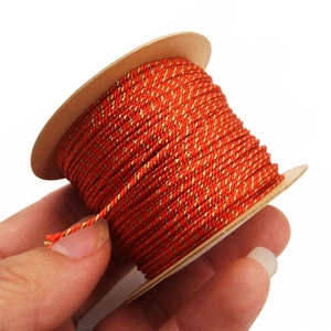 Close-up of 1mm red and gold twisted thread on a paper spool for DIY jewelry making